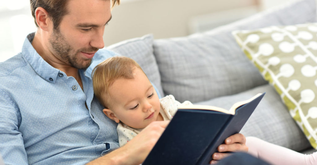 Vater liest Baby aus Buch vor, wenn es nicht alleine schläft