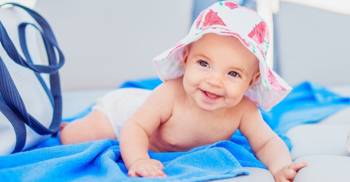 lachendes Baby auf einem Badetuch