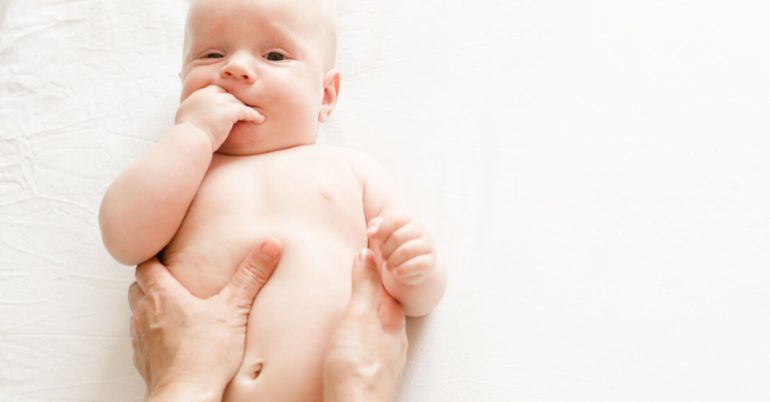 Baby mit Kolik wird massiert