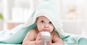 Baby nuckelt an Flasche
