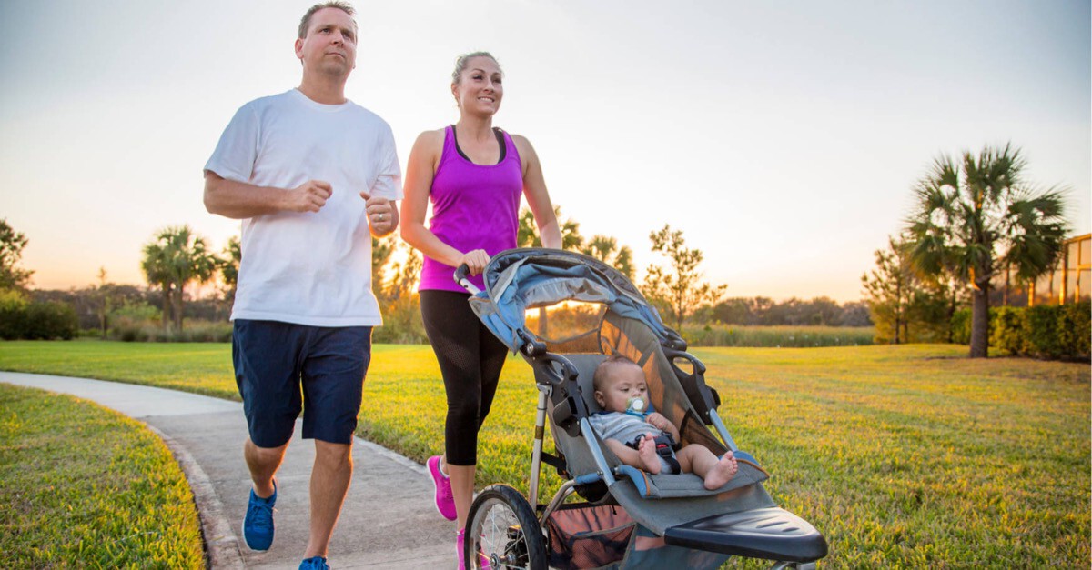 Familie läuft mit Kinderwagen