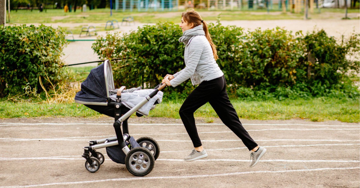 Frau mit Buggy auf Laufbahn