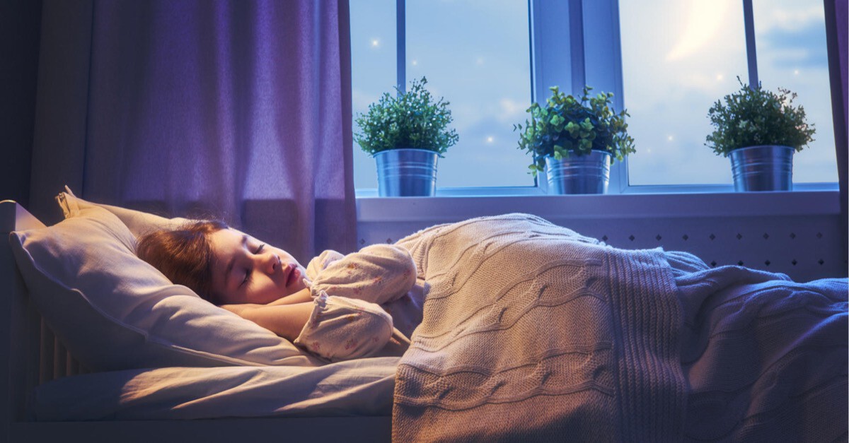 Mädchen schlläft am Abend im Bett