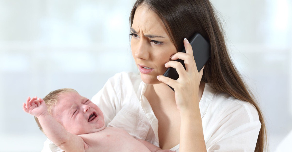 Frau mit schreiendem Baby telefoniert