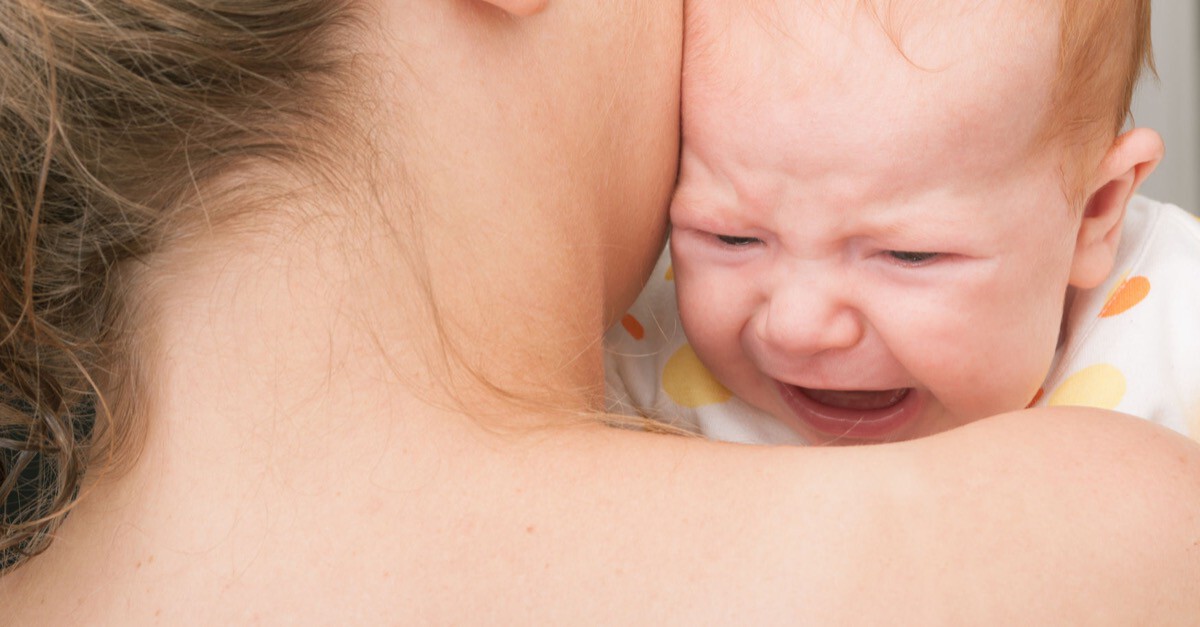 schreiendes Baby wird von Mutter gehalten