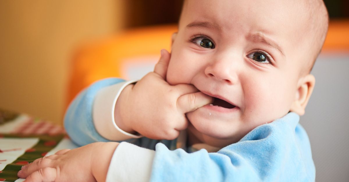Baby weint und kaut auf Finger