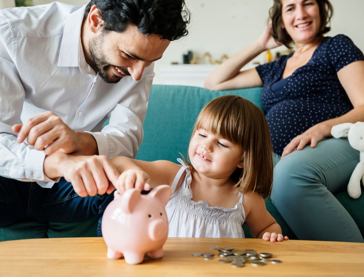 Familie schmeißt Geld in Sparschwein