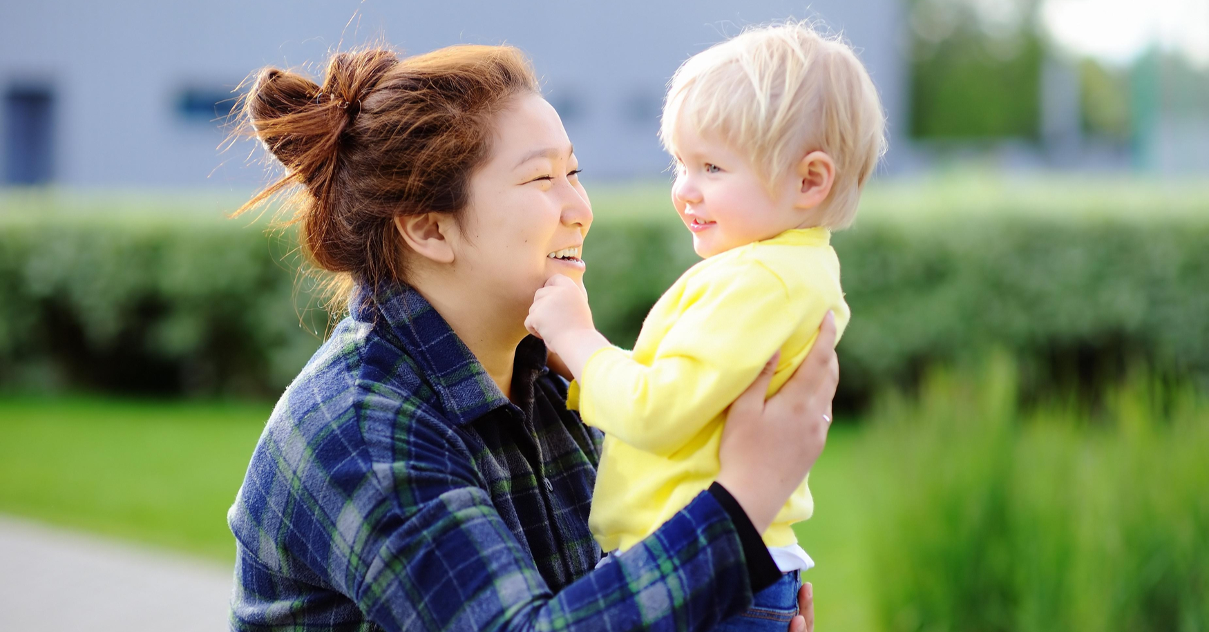 Asiatische Frau lacht mit Kleinkind